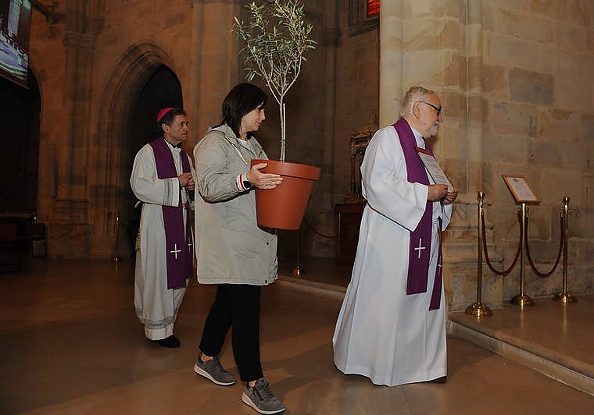 Joseba Segura (a la izquierda) precedido por una voluntaria y el sacerdote Josu López
