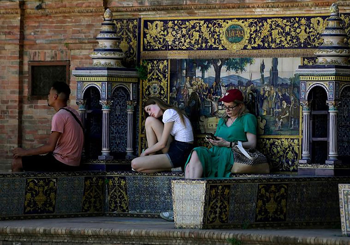 Personas descansa a la sombra ayer en Sevilla
