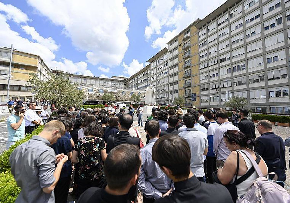 Un grupo de fieles congregados esta mañana ante el Hospital Gemelli, frente a la estatua del Papa Juan Pablo II