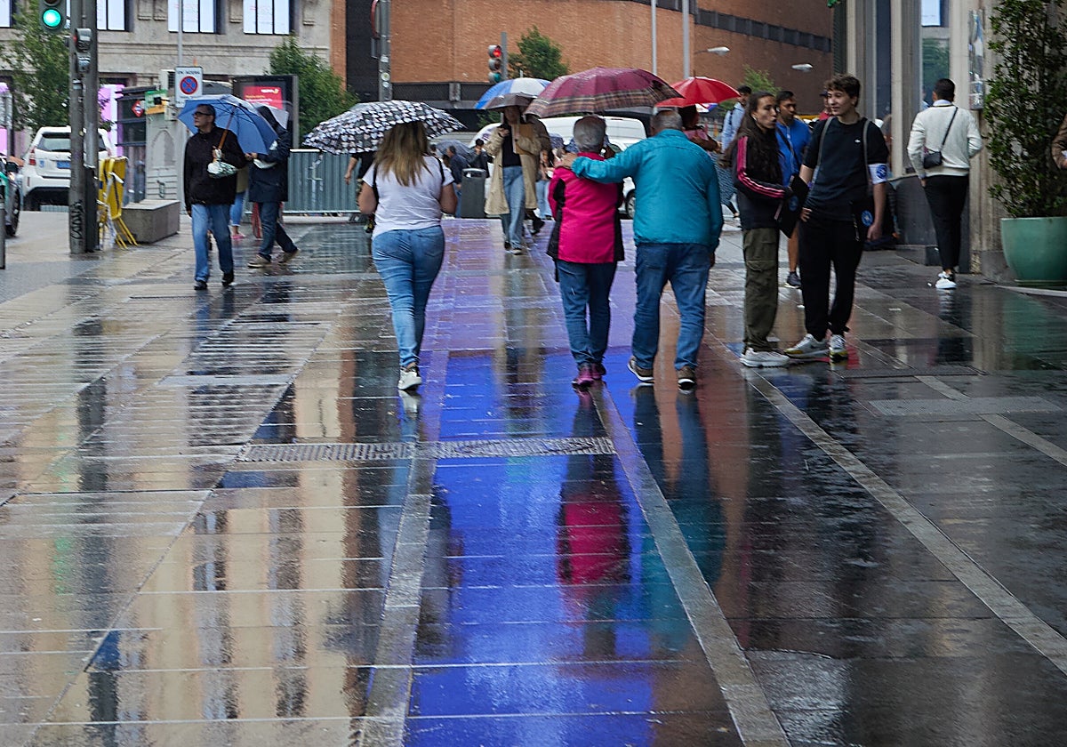 Varias personas con paraguas caminan por el centro de Madrid