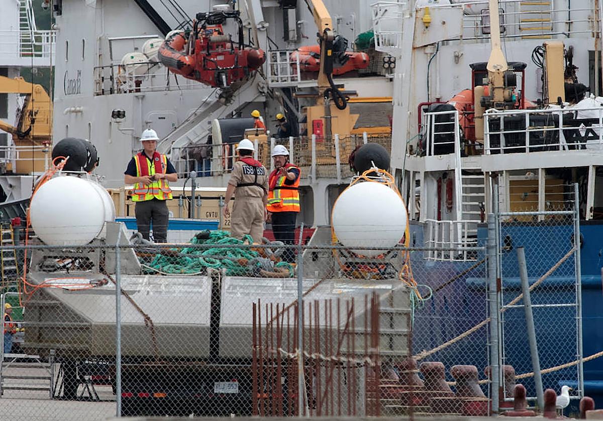 Varias personas inspeccionan el barco Polar Prince y la barcaza de despliegue, utilizada en el sumergible Titan