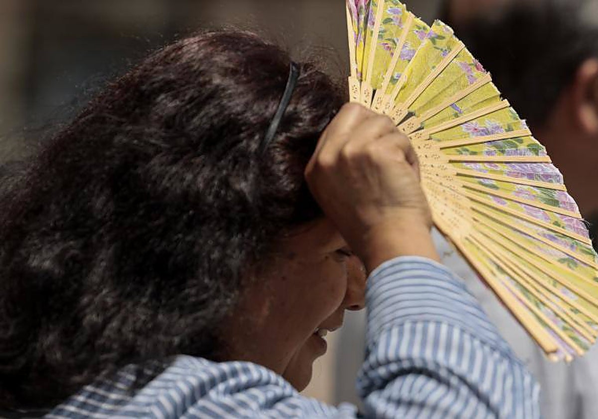 Una mujer se cubre del calor en Valencia