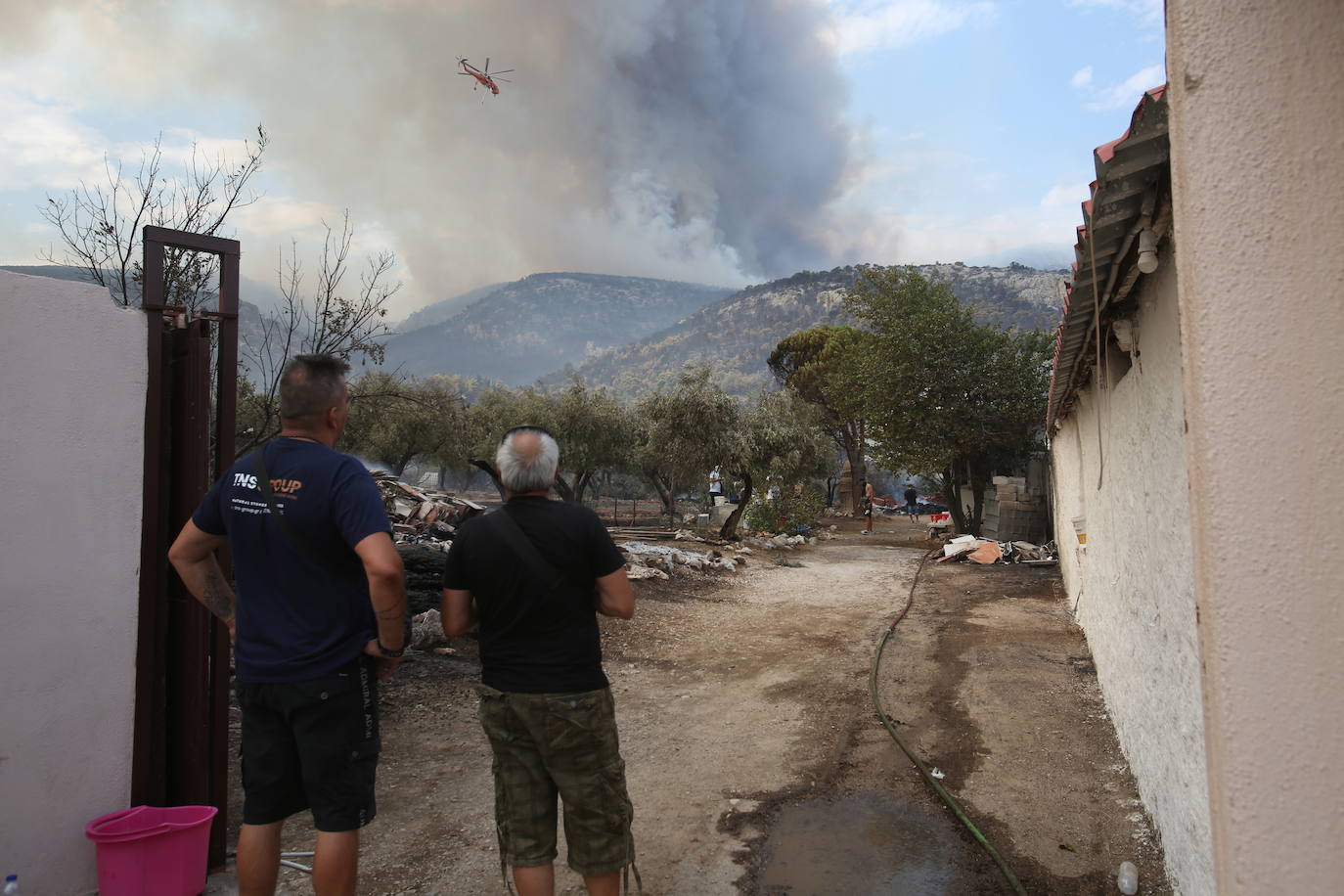 Residente observan el incendio en la aldea de Agia Paraskevi (Grecia)