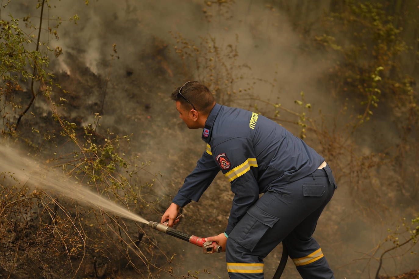Un bombero intenta extinguir un incendio en una zona entre las aldeas de Sapes y Sicorrachi, cerca de Alejandrópolis (Grecia)