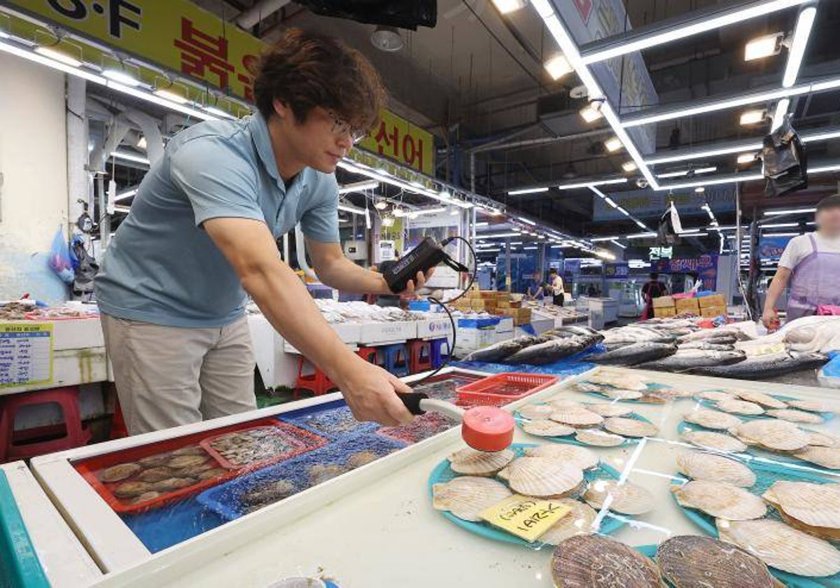 Un comerciante mide los niveles de radiación de las vieiras procedentes de Japón en un mercado pesquero de Corea del Sur