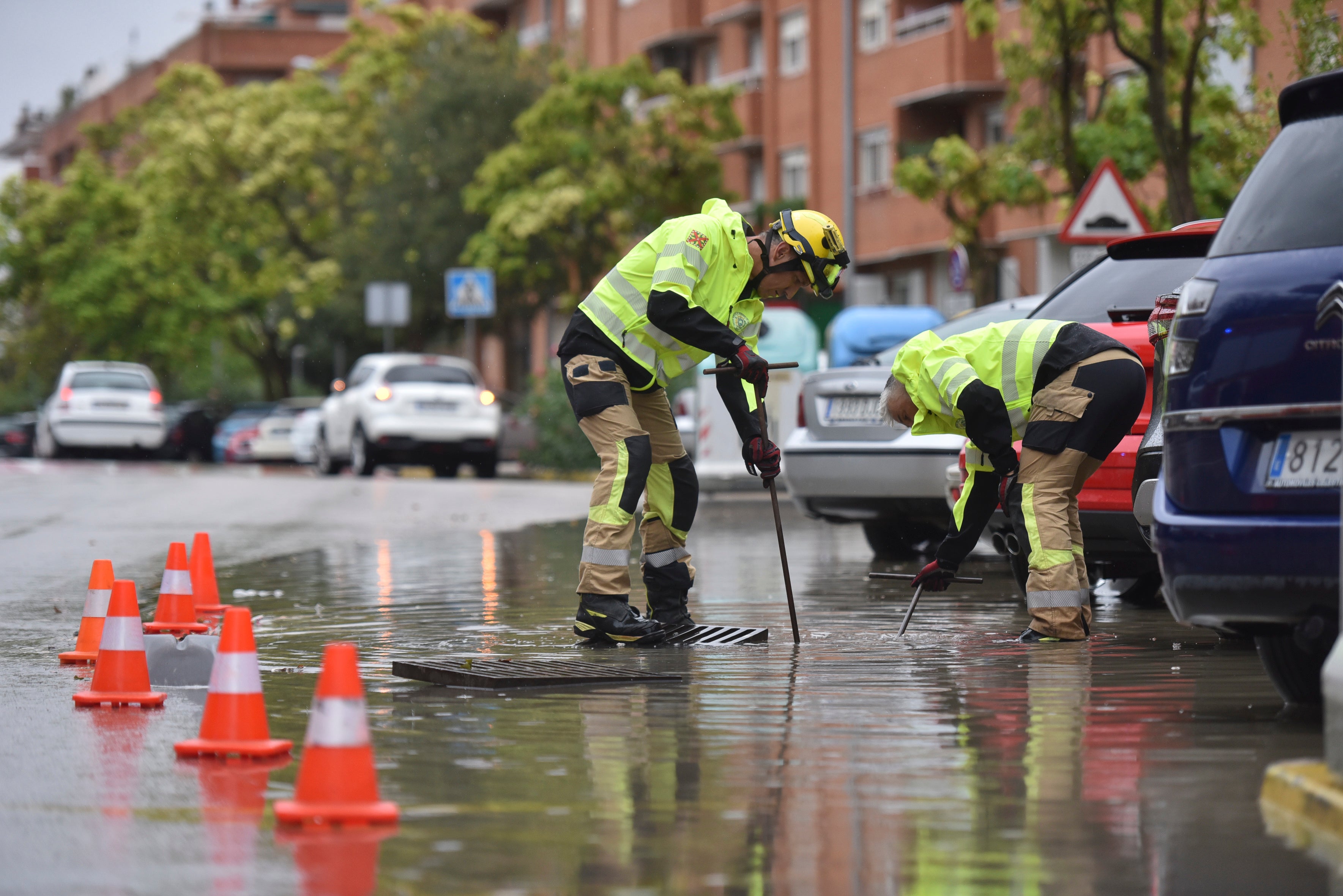 Dos hombres desatascan una alcantarilla en Huesca