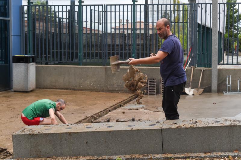 Varias personas limpian una cañería para evitar inundaciones, este 4 de septiembre, en Navalcarnero, Madrid