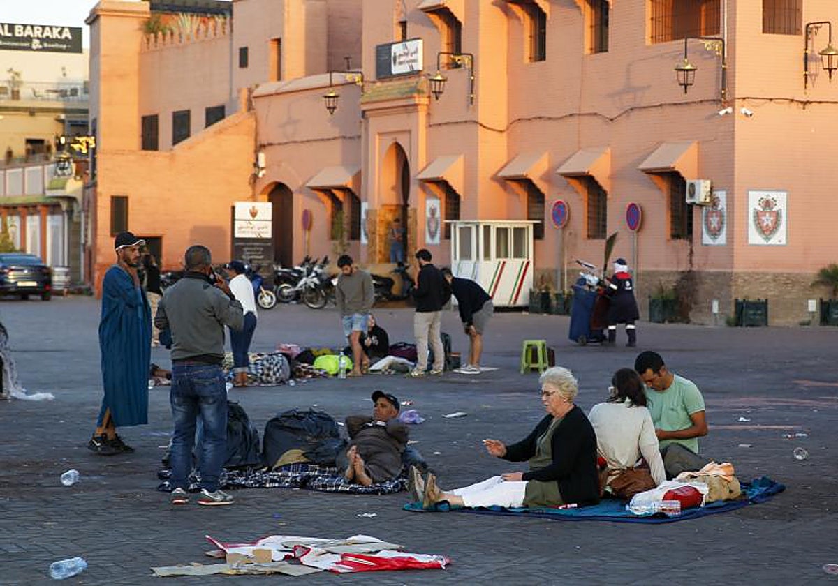 Varias personas descansan en medio de una calle de Marrakech a primera hora de este sábado