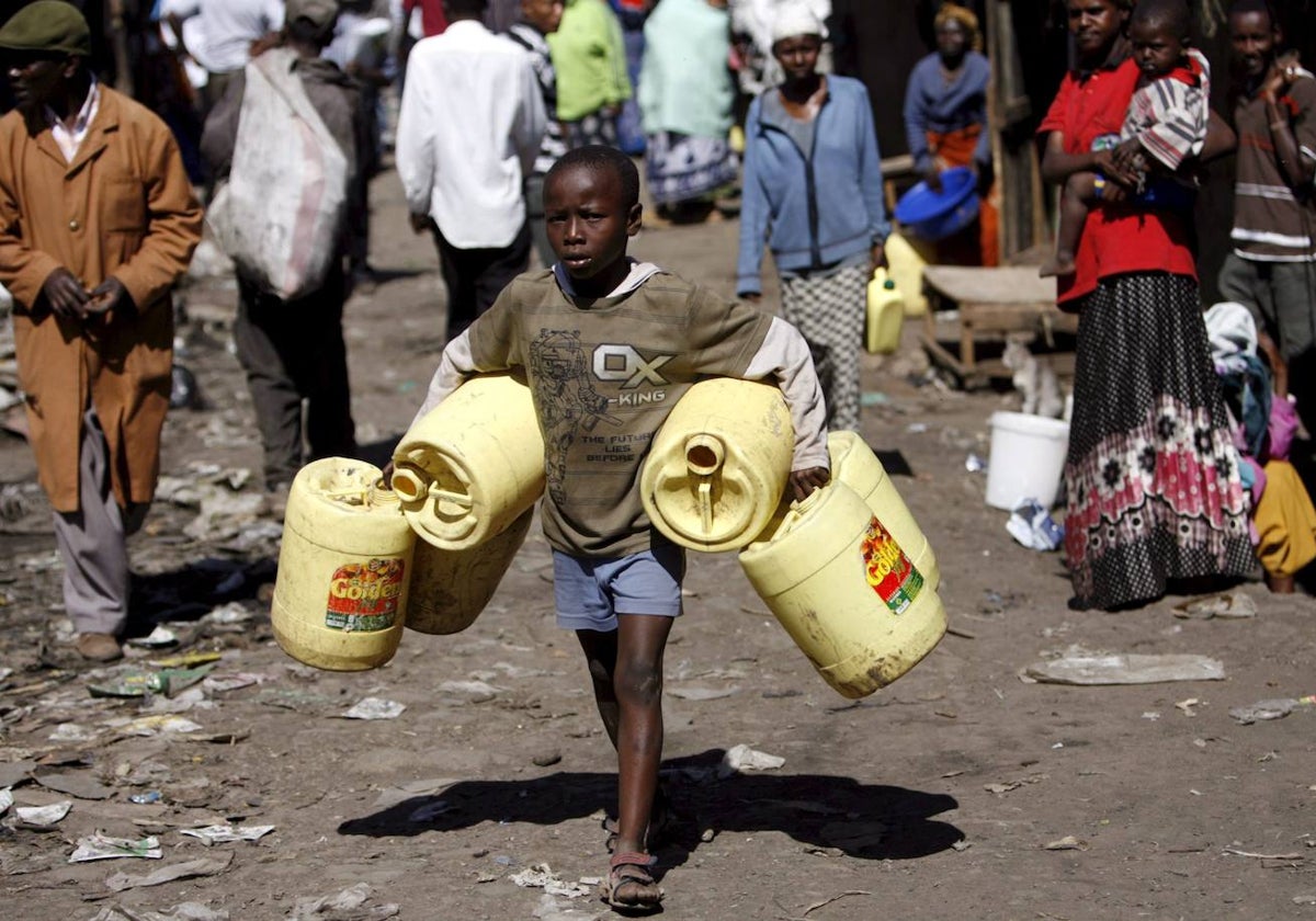 Un niño transporta bidones de agua en Nairobi, capital de Kenia