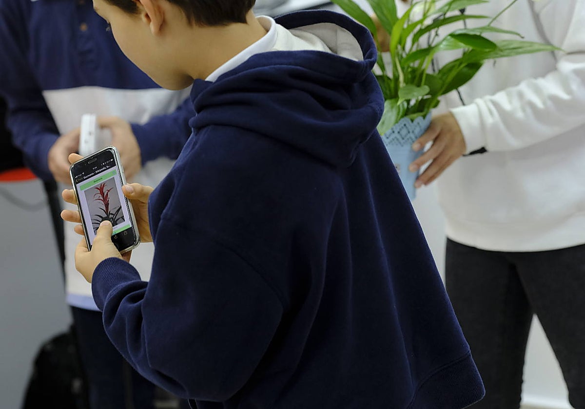 Un niño en el colegio con su teléfono móvil