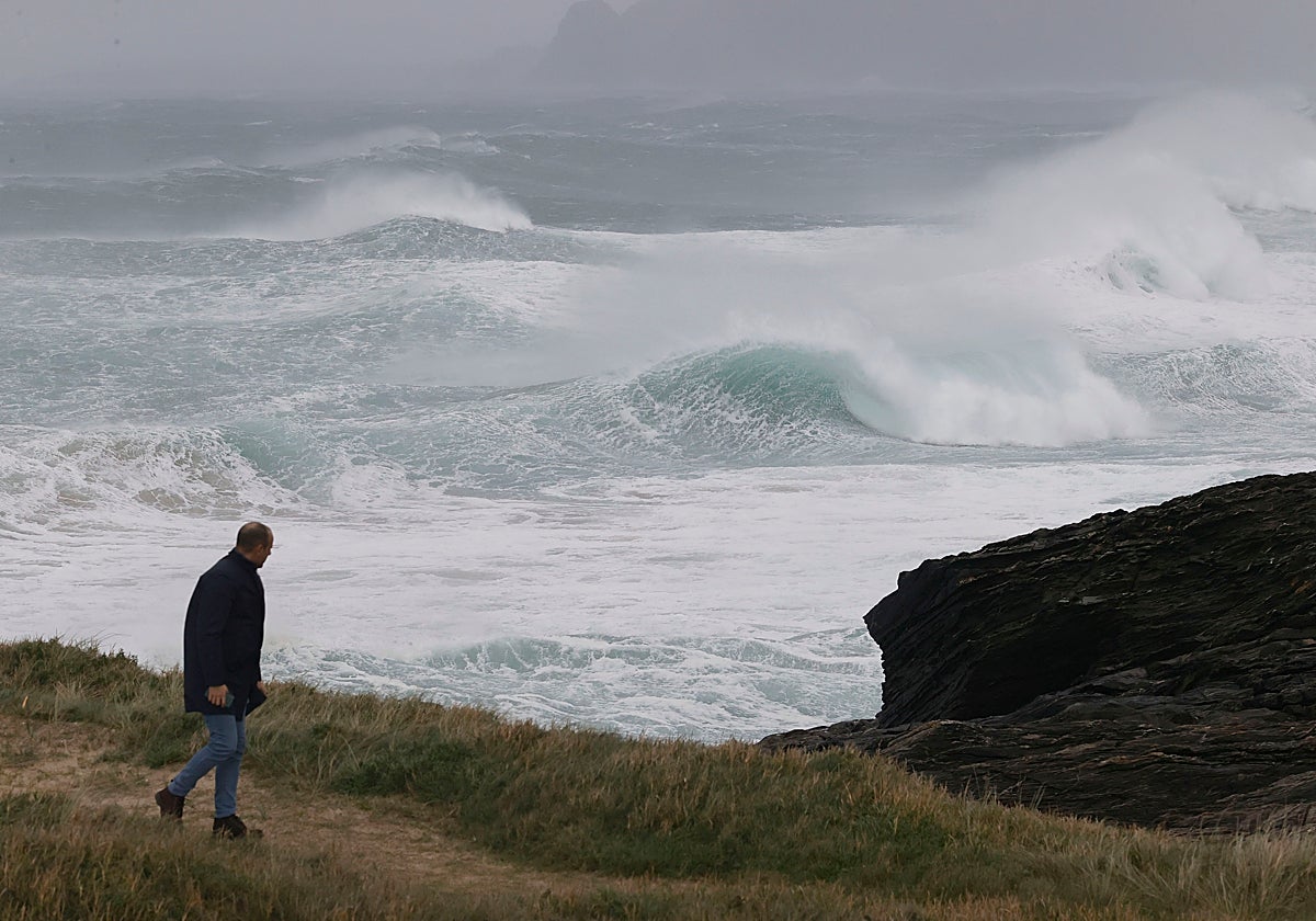 Un hombre pasea al lado del mar en las proximidades de la playa de Ponzos de Ferrol donde en alerta por fuerte oleaje