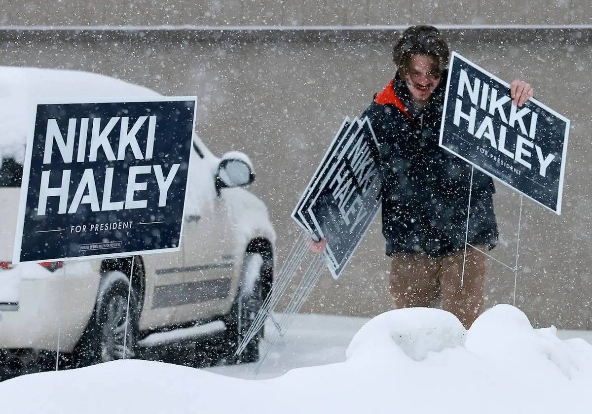 Un hombre pone carteles a favor de Nikki Haley en iowa