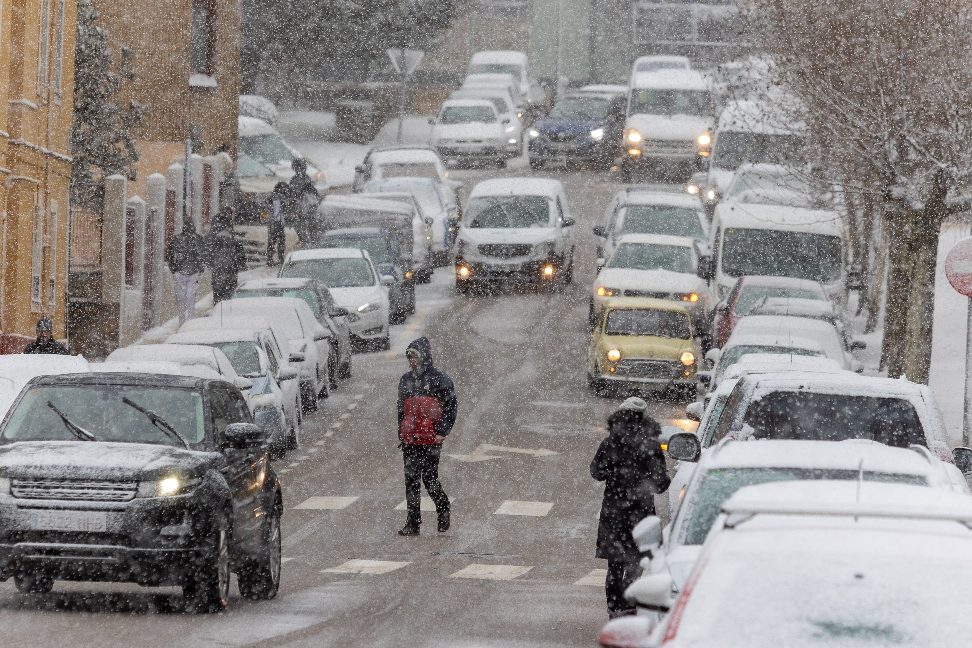 Varios coches circulan mientras nieva en Soria