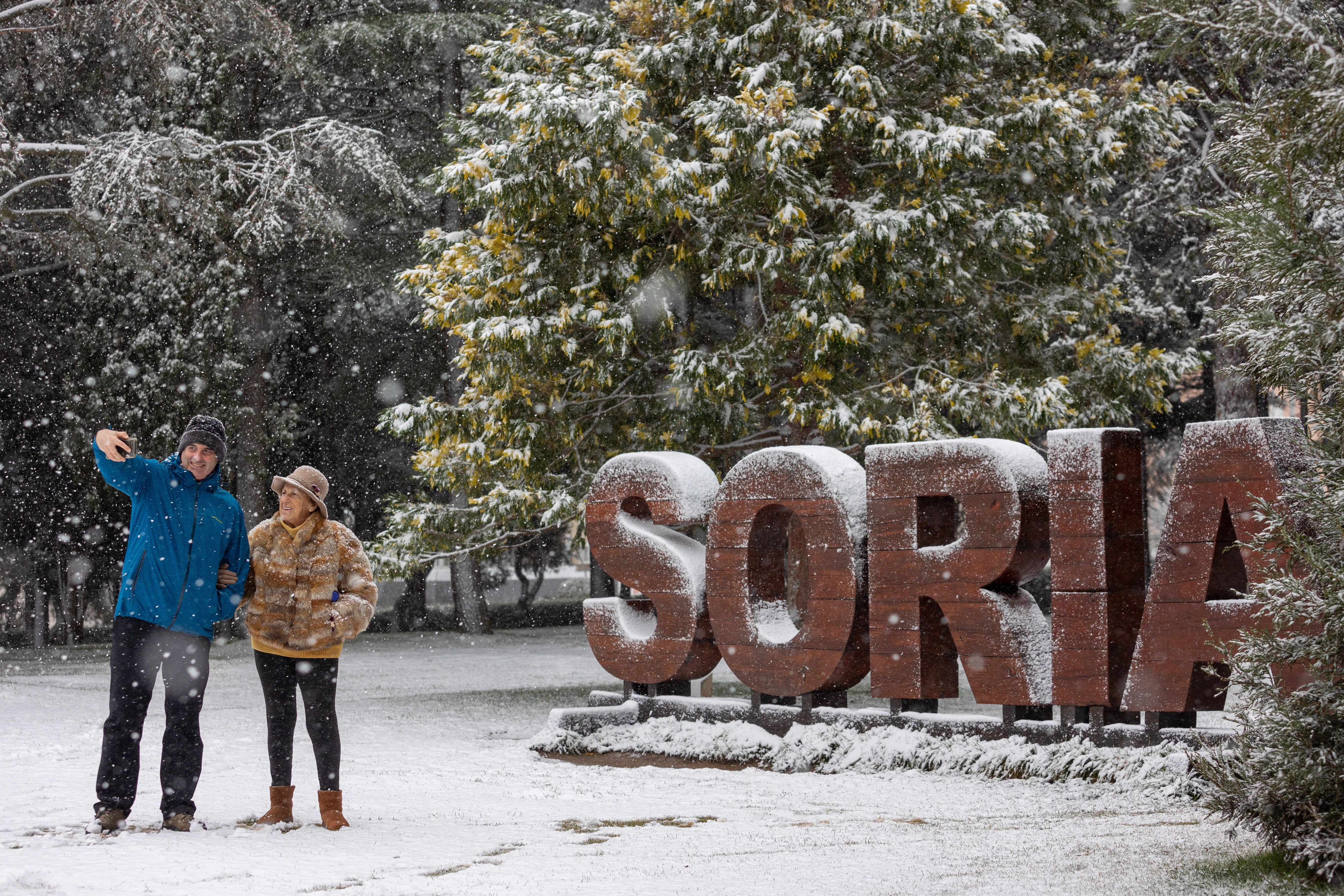 Dos personas se hacen una foto mientras nieva, a 19 de enero de 2024, en Soria