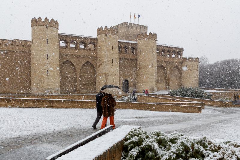 Personas caminan bajo la nieve, en Zaragoza