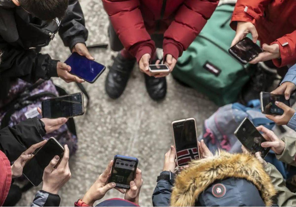 Varios jóvenes con su teléfonos móviles