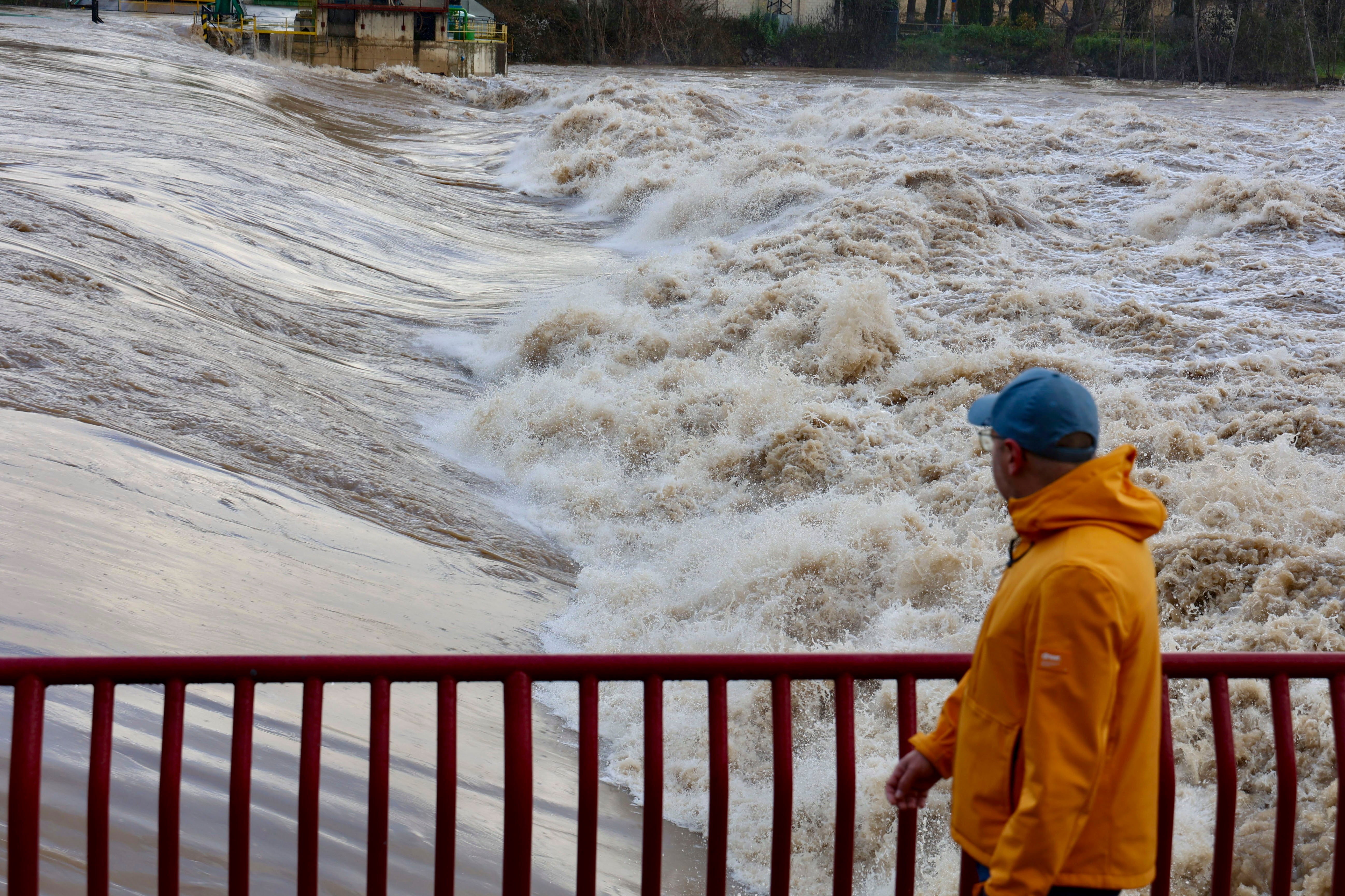 Un hombre mira la crecida del río Ebro a su paso por Logroño (La Rioja).