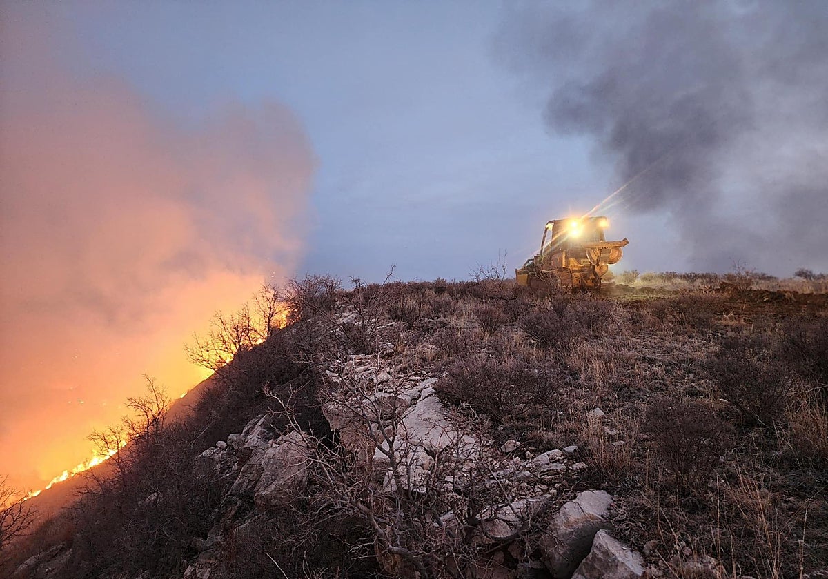 Una excavadora del Servicio Forestal de Texas, EE.UU., construye una línea de contención para luchar contra el incendio del pasado 27 de febrero