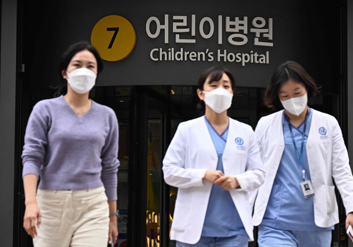 Sanitarios caminan frente a un hospital infantil en Seúl