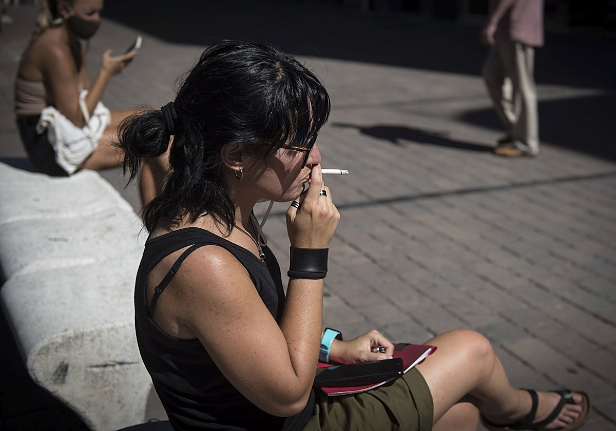 Una mujer fuma un cigarrillo