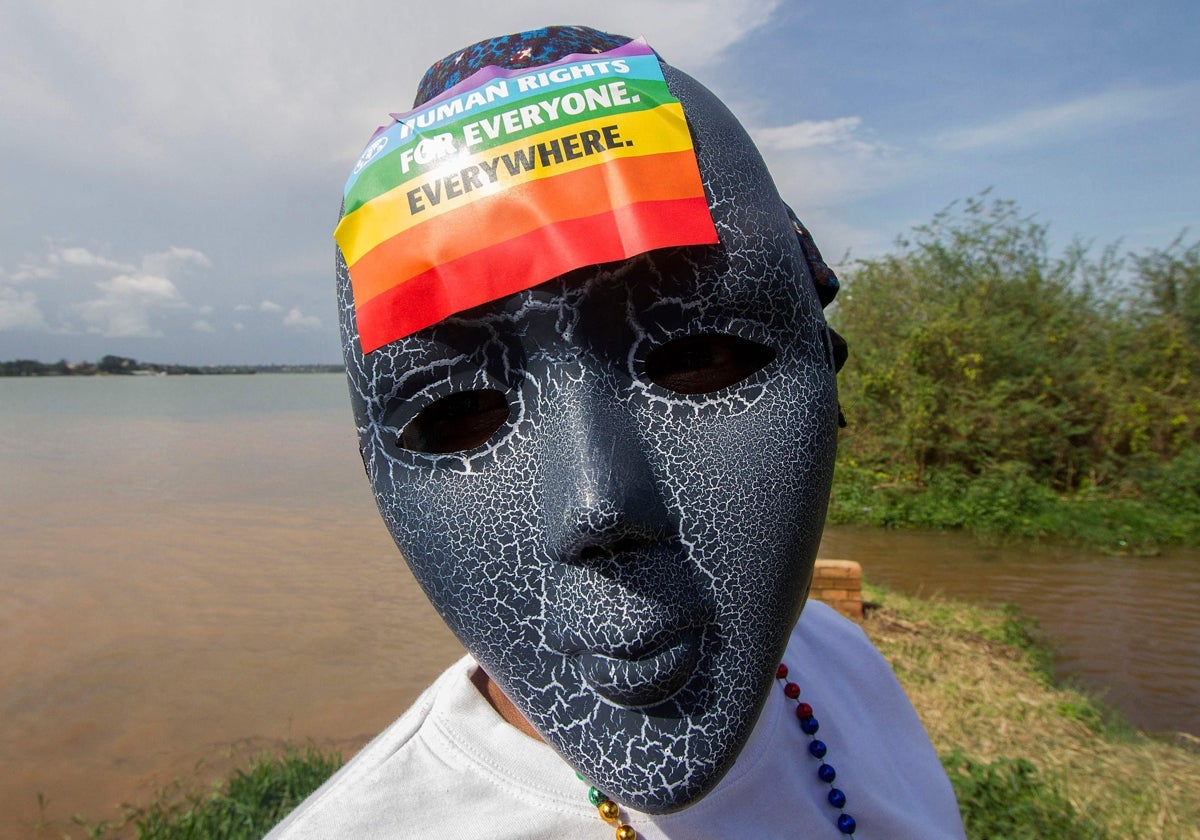 Un ugandés con una máscara con una pegatina del arco iris