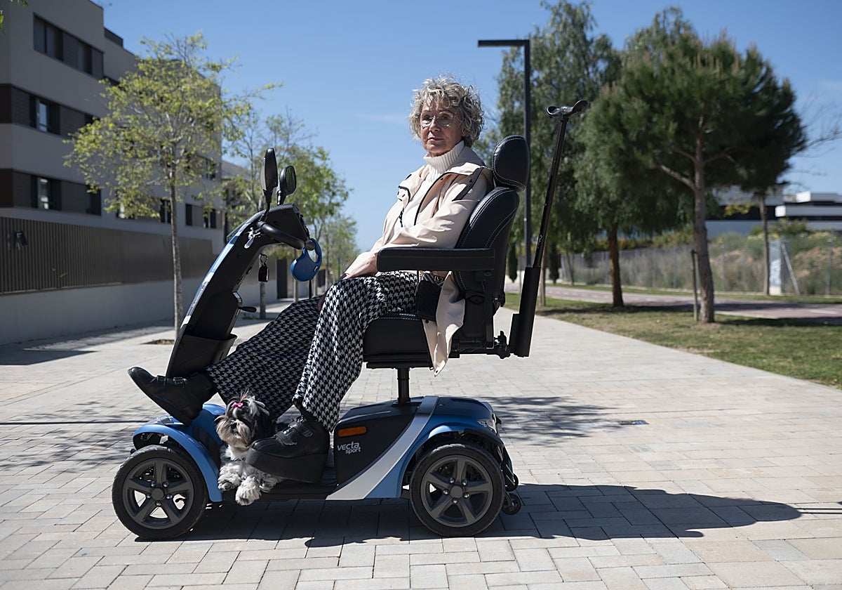 Marta Sirera en la silla motorizada por la que se mueve, junto a su perrita y sus muletas