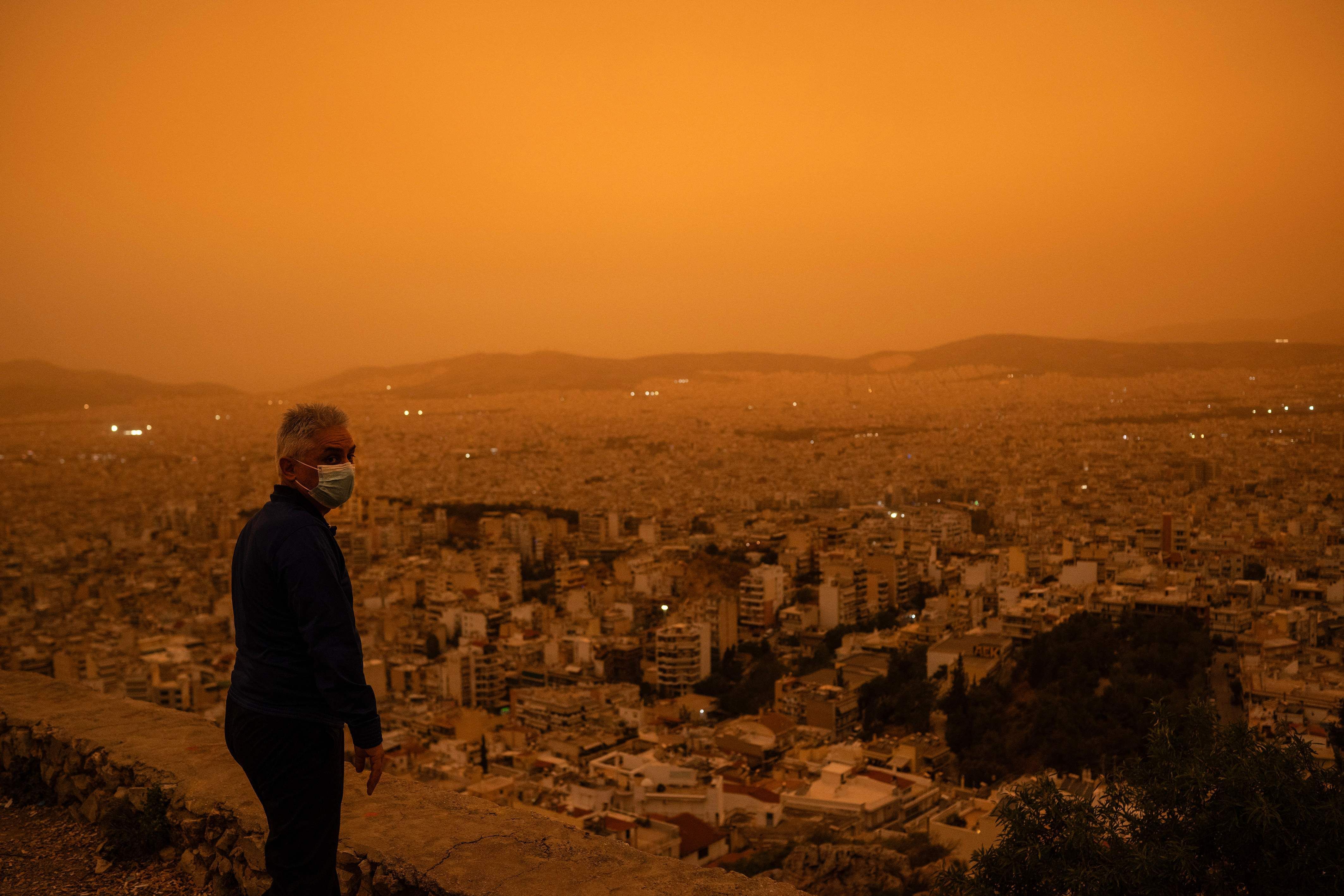 Un hombre observando la calima en Atenas