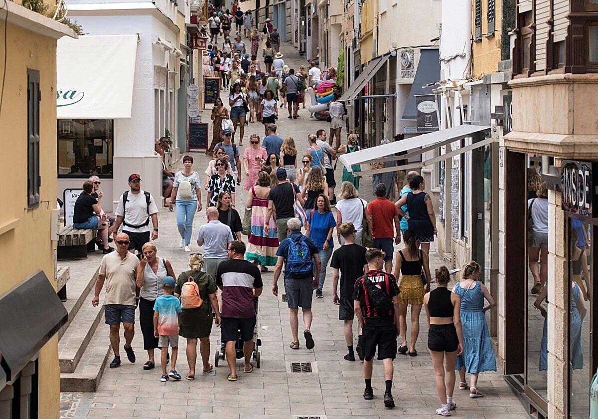 Un grupo de personas camina por las calles de Mahón, Menorca