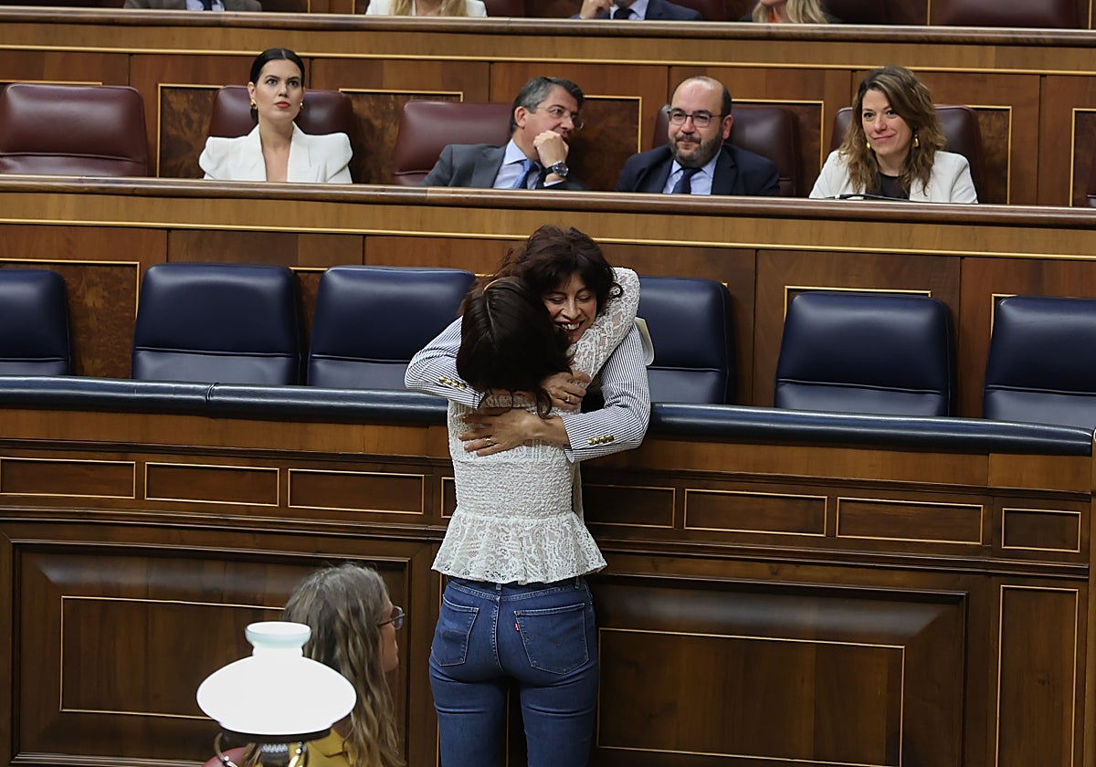 La ministra de Igualdad, Ana Redondo (detrás), se abraza con la diputada del PSOE Andrea Fernández, durante la sesión plenaria del Congreso