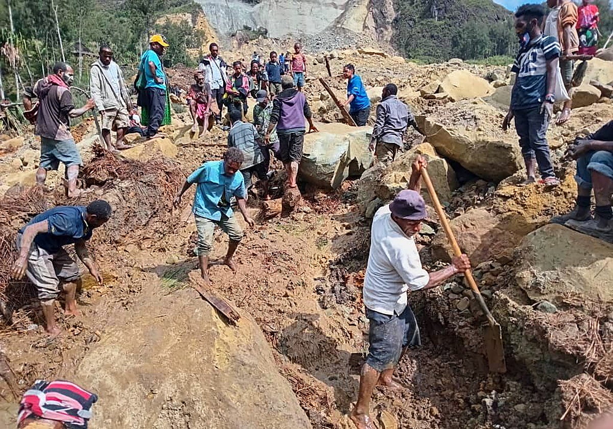 Varios habitantes locales cavando entre los escombros para buscar a sus familiares desaparecidos en Papúa Nueva Guinea
