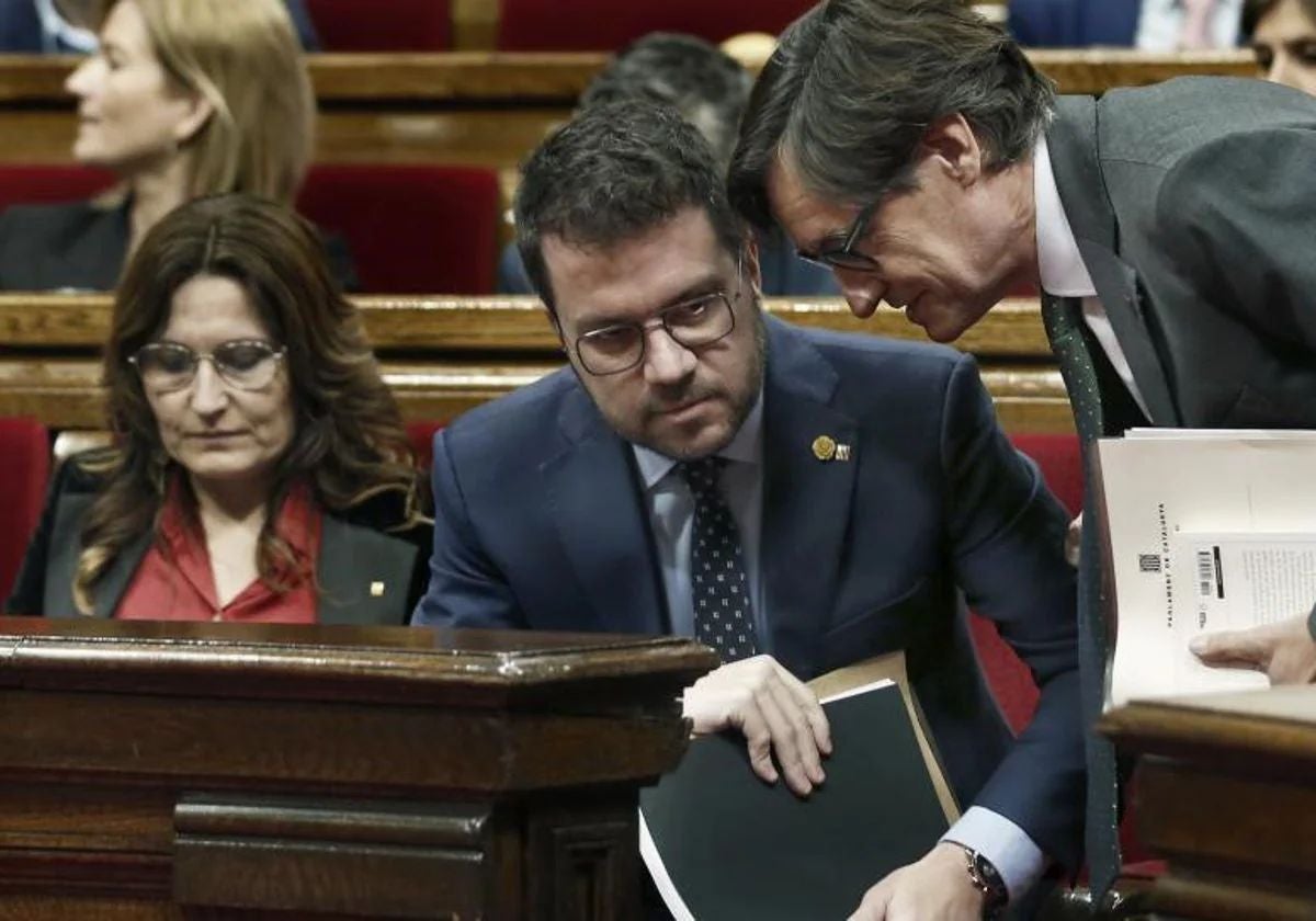 Pere Aragonès y Salvador Illa conversan en el Parlamento de Cataluña, en febrero de este año