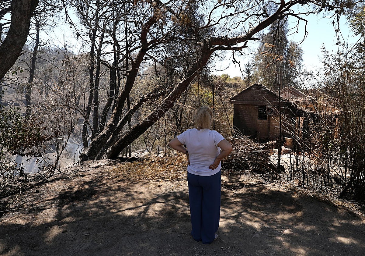Una mujer observa los estragos del incendio de Atenas, Grecia