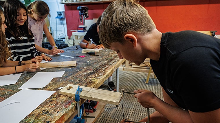 Un alumno trabaja la madera en el taller de talla