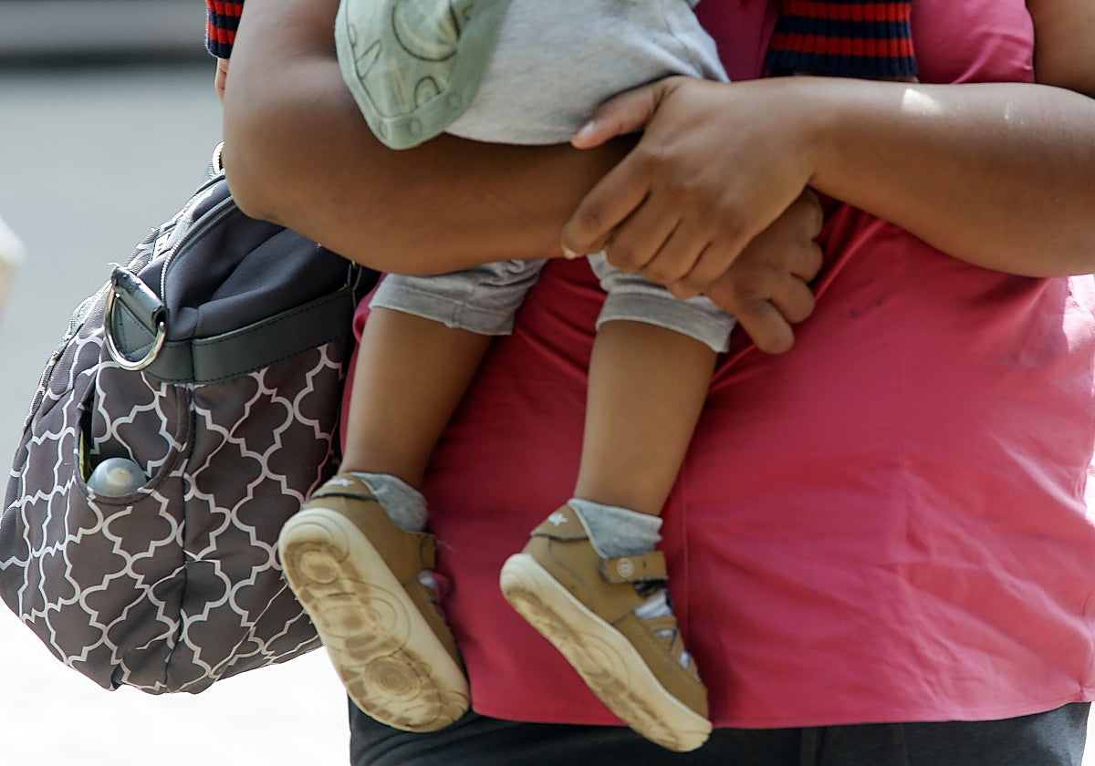 Una mujer traslada a un bebé antes de comenzar su jornada laboral