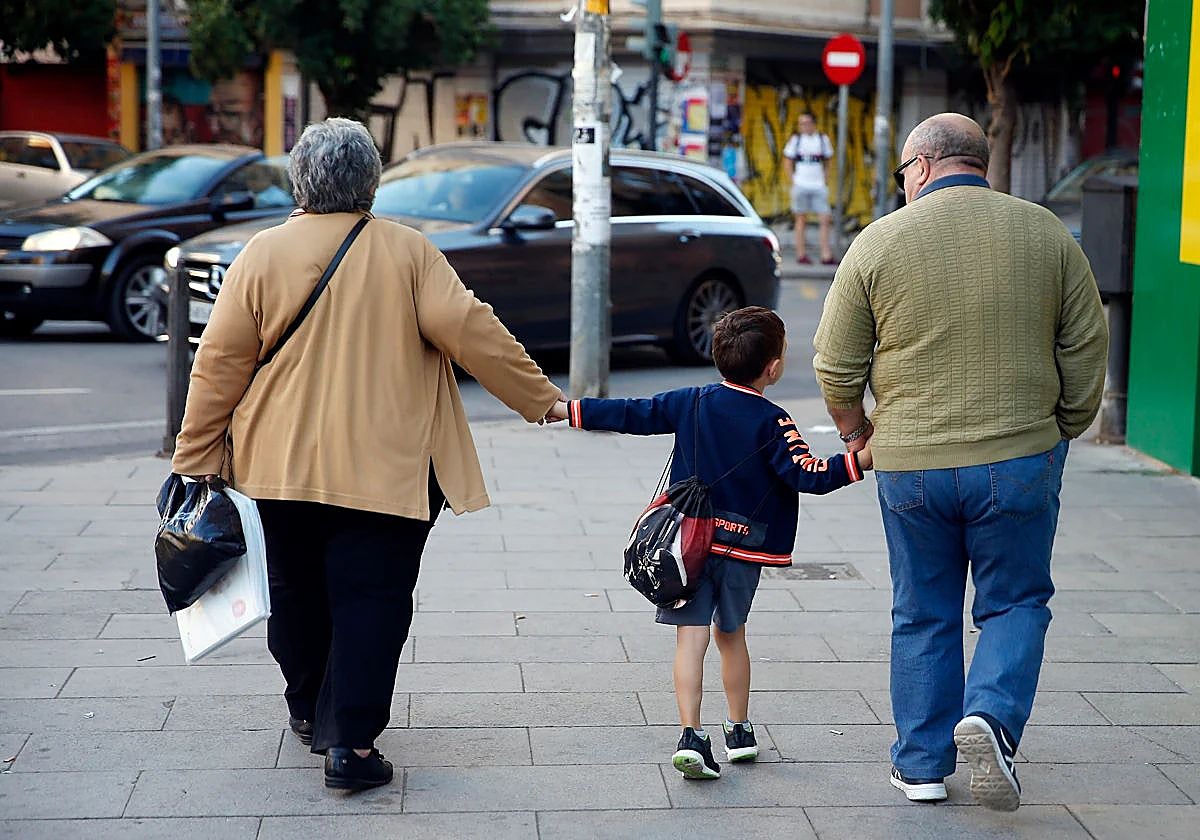 Unos abuelos llevan a su nieto a la escuela