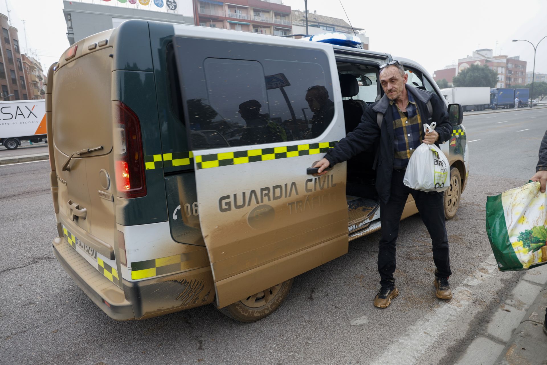 Una persona rescatada de una de las zonas afectadas por las inundaciones baja de un coche de la Guardia Civil en la ronda Sur de la ciudad