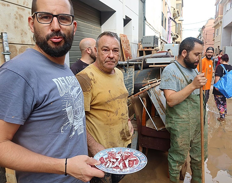 Unos vecinos de Alfafar almuerzan fuet que les han traído los voluntarios