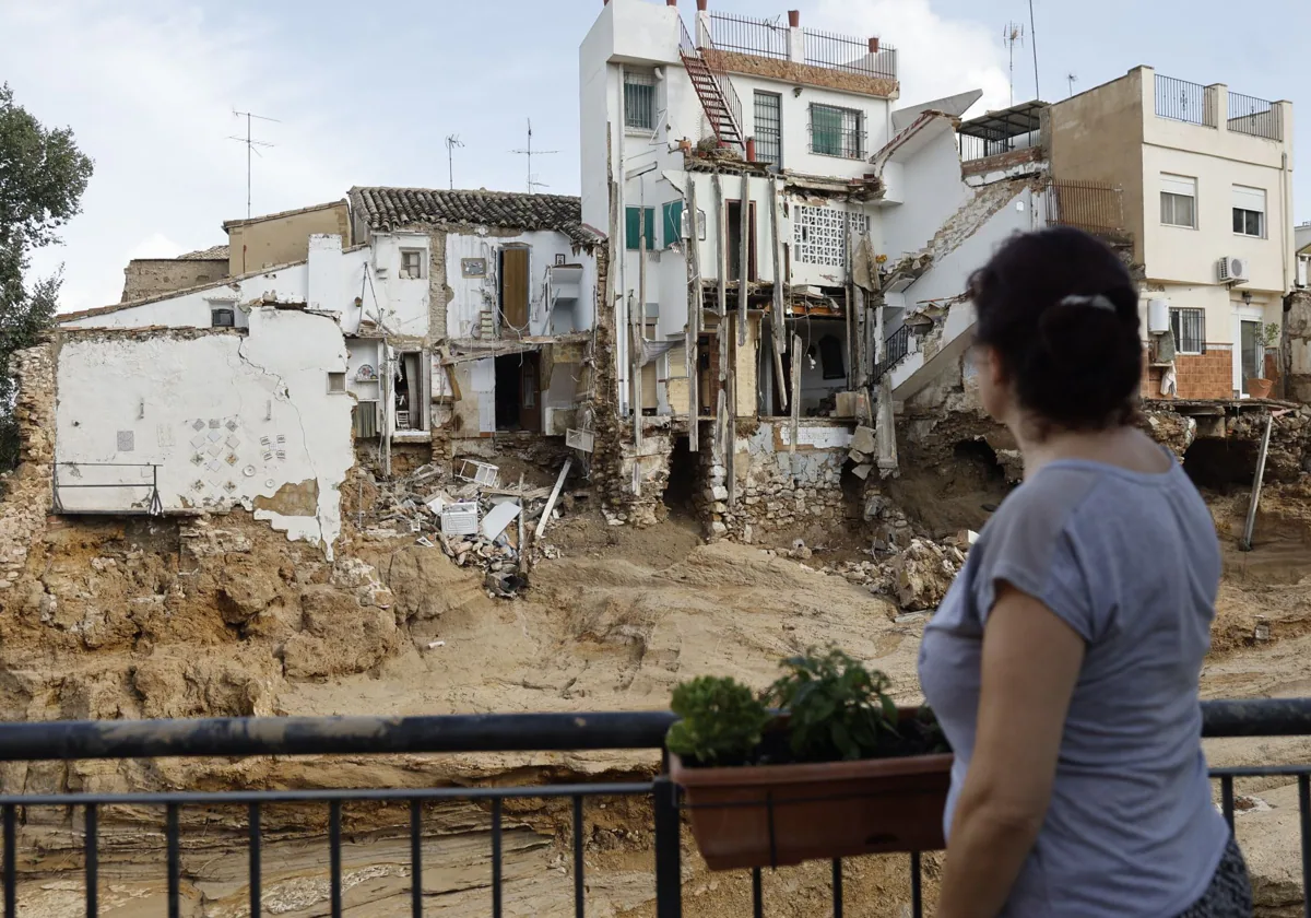 Una mujer observa varias casas dañadas en Chiva tras la DANA que ha asolado el sureste español