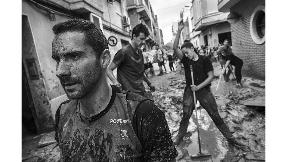 Voluntarios ayudan como pueden a retirar escombros, lodo y agua de las calles de Paiporta tras el paso de la DANA