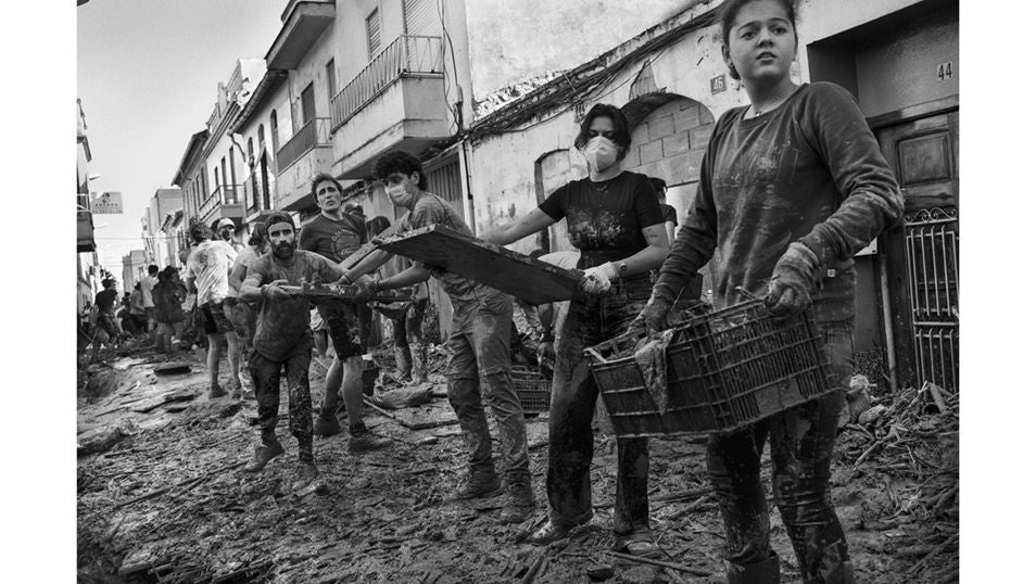 Una cadena humana de voluntarios se organizan para limpiar de escombros y lodo las calles de la localidad de Paiporta, destrozada por el paso de la DANA