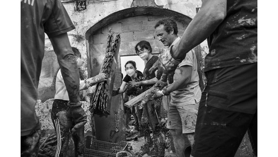 Una cadena humana de voluntarios se organizan para limpiar de escombros y lodo las calles de Paiporta