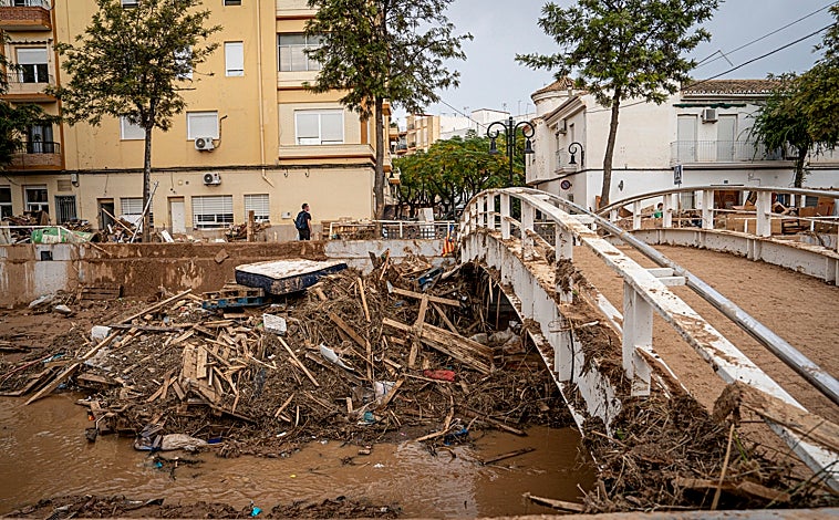 Imagen principal - Arriba, el estado actual del barranco. Abajo, redes de ayuda en la casa de Andalucía (izquierda) y voluntarias limpiando (derecha)