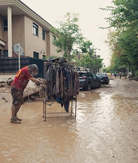 Imagen secundaria 2 - El barro cubre de marrón Picaña, una de las localidades más afectadas por las riadas causadas por la DANA de Valencia. Mónica Carretero, todavía conmocionada, limpia con ayuda de voluntarios su casa. Daniel March se queja de la tardanza en retirar de su calle los escombros acumulados a las puertas de las casas