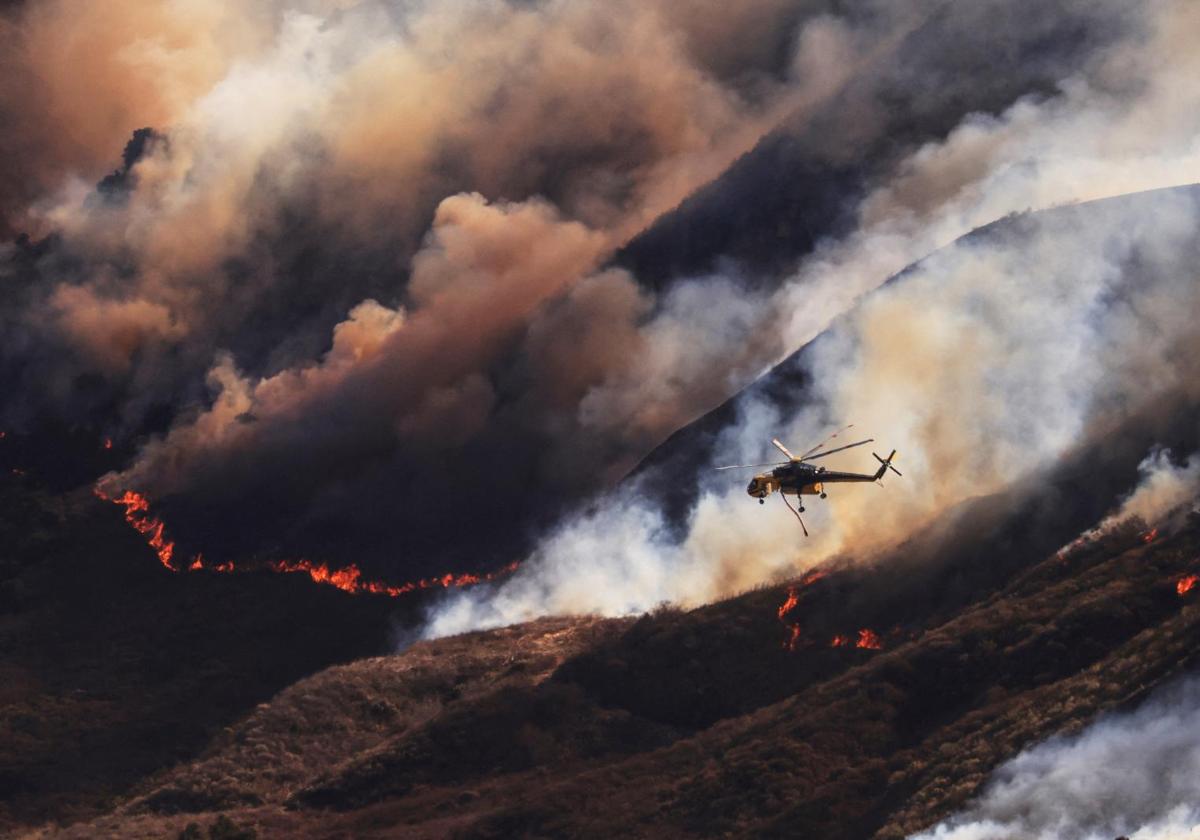 Un helicóptero intentado apagar el fuego provocado en Mountain Fire en Santa Paula, California (EE.UU.)