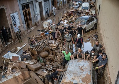 Imagen secundaria 1 - Decenas de policías voluntarias, sobre todo catalanes y vascos, se vuelcan para ayudar a los afectados. Arriba, liberando una calle de Catarroja. Abajo a la izquierda, retirando un coche. A la derecha, mensajes de agradecimiento en restos apilados 