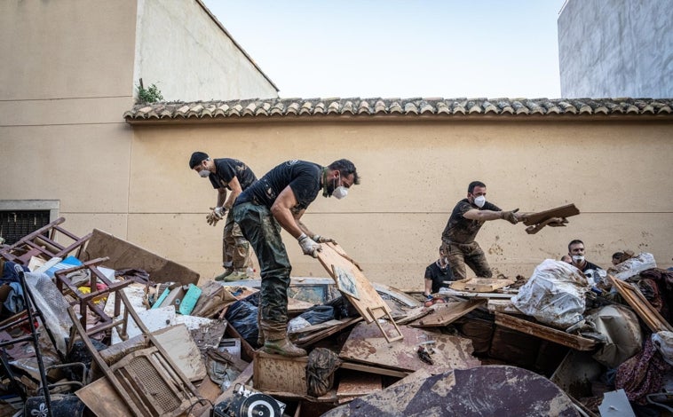 Imagen principal - Decenas de policías voluntarias, sobre todo catalanes y vascos, se vuelcan para ayudar a los afectados. Arriba, liberando una calle de Catarroja. Abajo a la izquierda, retirando un coche. A la derecha, mensajes de agradecimiento en restos apilados 