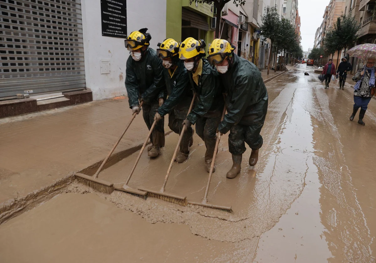 Un grupo de bomberos de Málaga trabaja en la limpieza de calles en Catarroja (Valencia) este miércoles