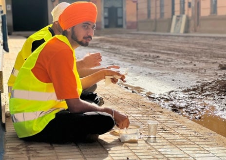 Imagen secundaria 1 - Arriba, la frutería de Sedaví donde la comunidad sij reparte verduras y frutas gratuitas a la població. Debajo, un momento de la comida antes de comenzar el trabjao. En la última foto, Amrik Singh, el sij de Llançà (Gerona) que ha dejado sus negocios para ayudar en Valencia. Antes estuvo también en Ucrania.