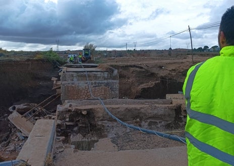 Imagen secundaria 1 - En la foto superior, el estado en que quedó el puente tras la crecida del rio Magro. Debajo, la tubería con el suministro de agua que se puedo instalar gracias a la flecha. Debajo, Luis Ignacio Soriano, con su arco, después de realizar el tercer lanzamiento, con el que consiguió cruzar la brecha 