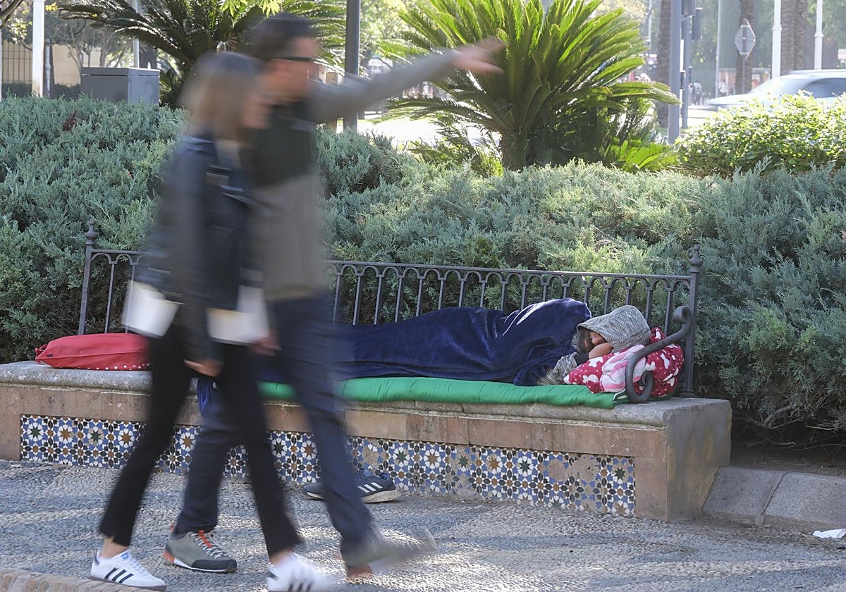 Un 'sin techo' duerme en un banco en Sevilla